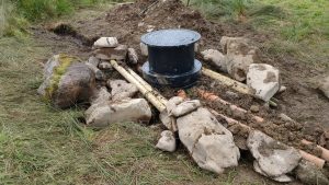 water tank pinned down by rocks
